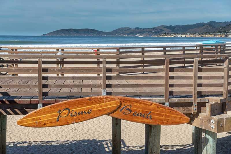 Two wood surfboards hanging from Pismo Beach pier