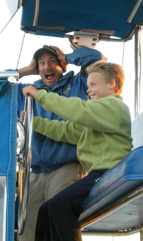 Child passenger at the helm of Manute'a during whale watching trip